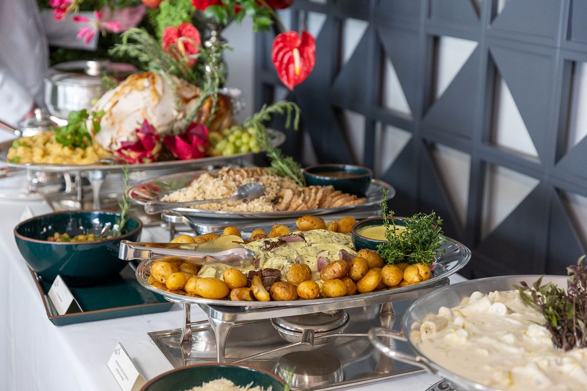 Mesa de buffet com pratos quentes e acompanhamentos