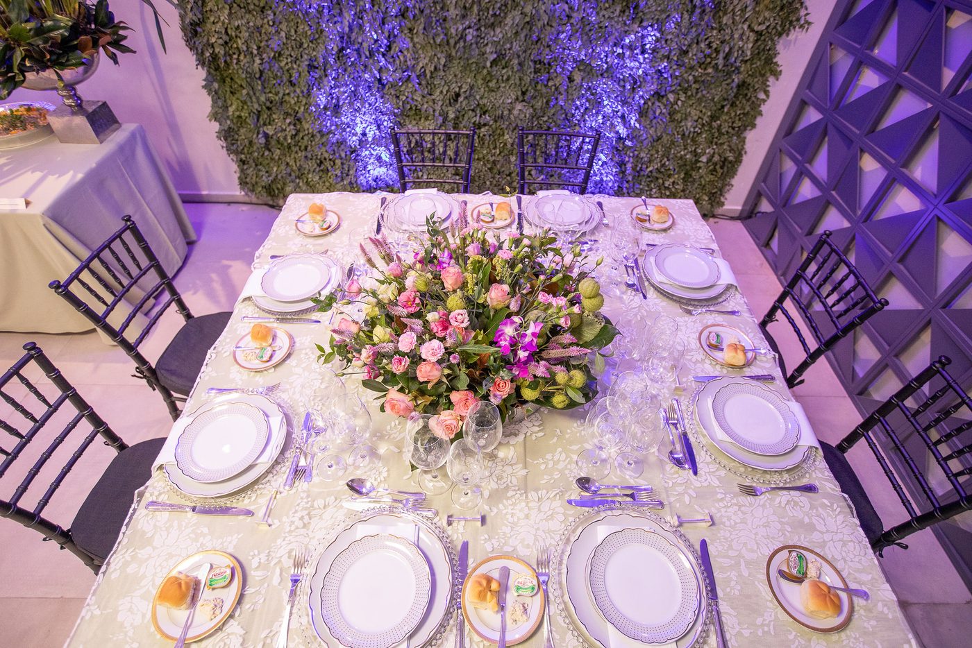 Mesa posta para evento social com arranjo floral central